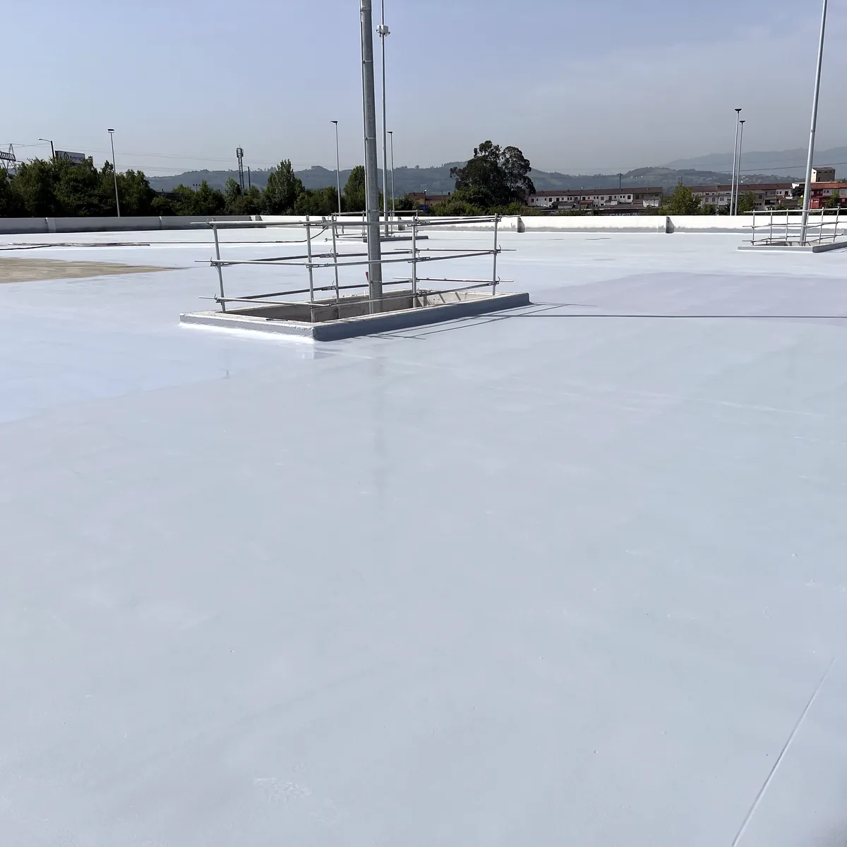 Finished rooftop parking waterproofing in La Línea, with light posts and railings