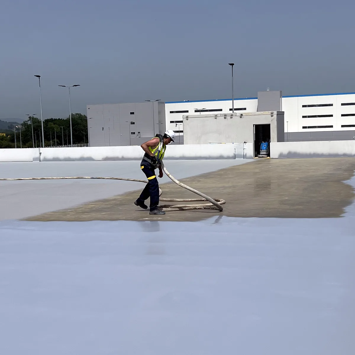 Grey and beige areas of the roof deck meeting at a parapet