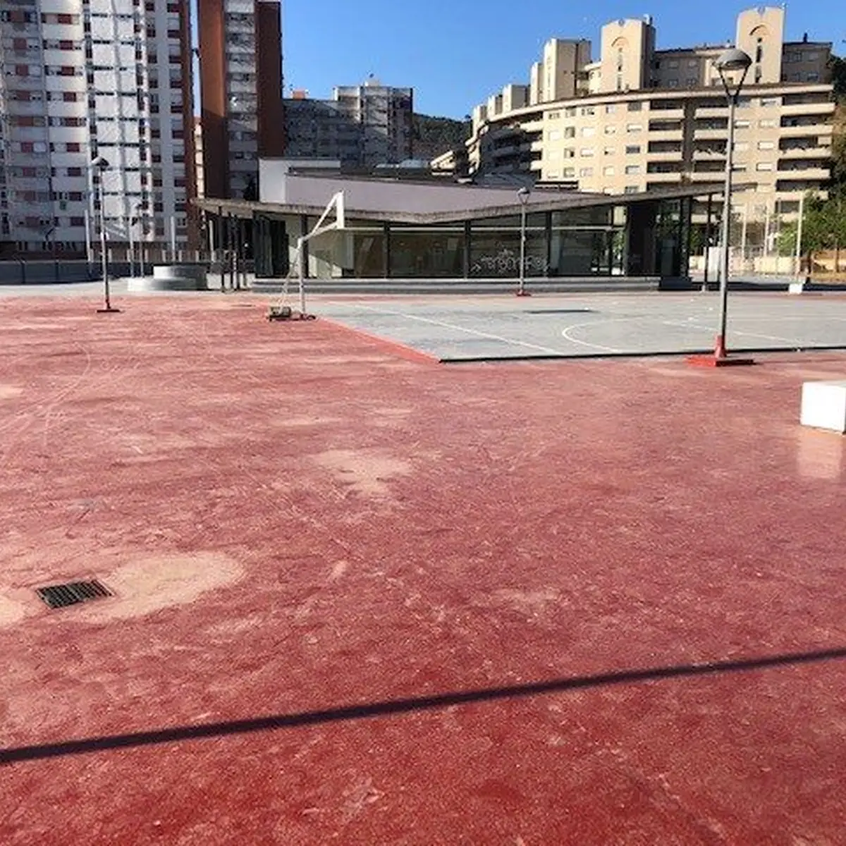 Worn red court surface on the supermarket roof before resurfacing, Montcada i Reixac