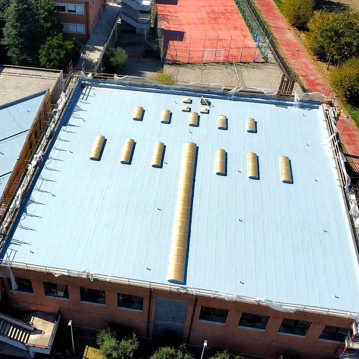 Cubierta revestida y fachada de ladrillo del Liceo Bruno Touschek en Grottaferrata, desde el aire