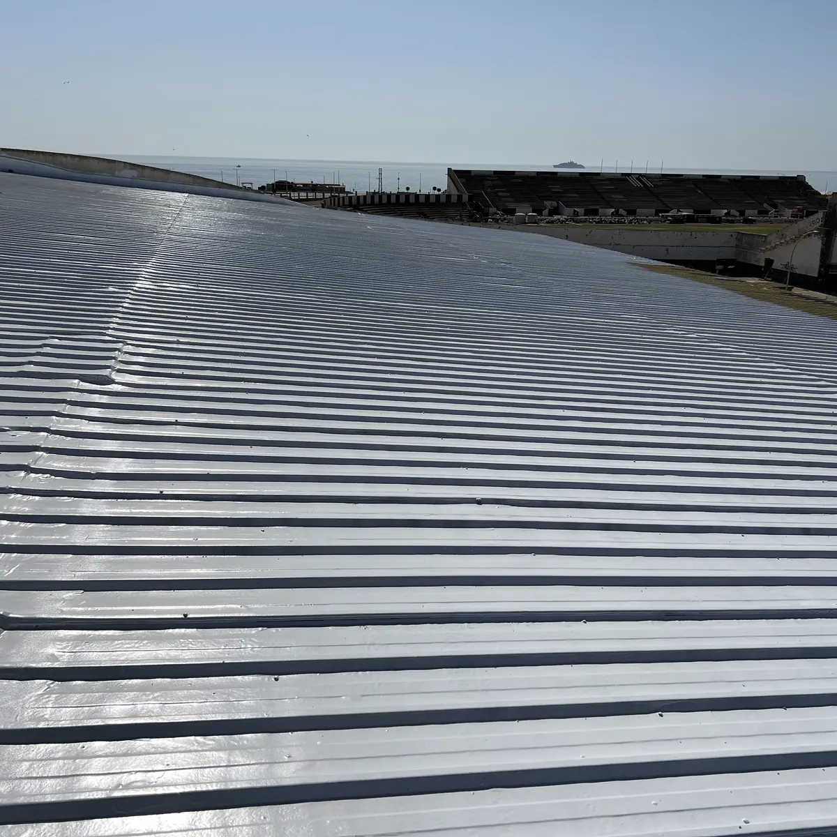 Glossy white Colodur over the ribbed metal roof toward the sea, La Línea