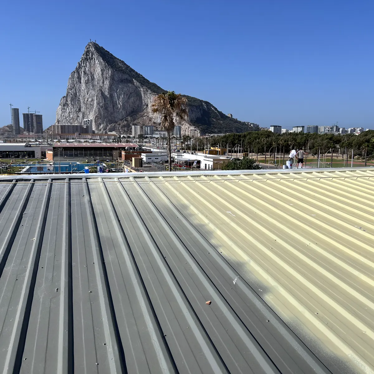 Bare grey sheet beside the pale yellow coat, with the Rock of Gibraltar behind