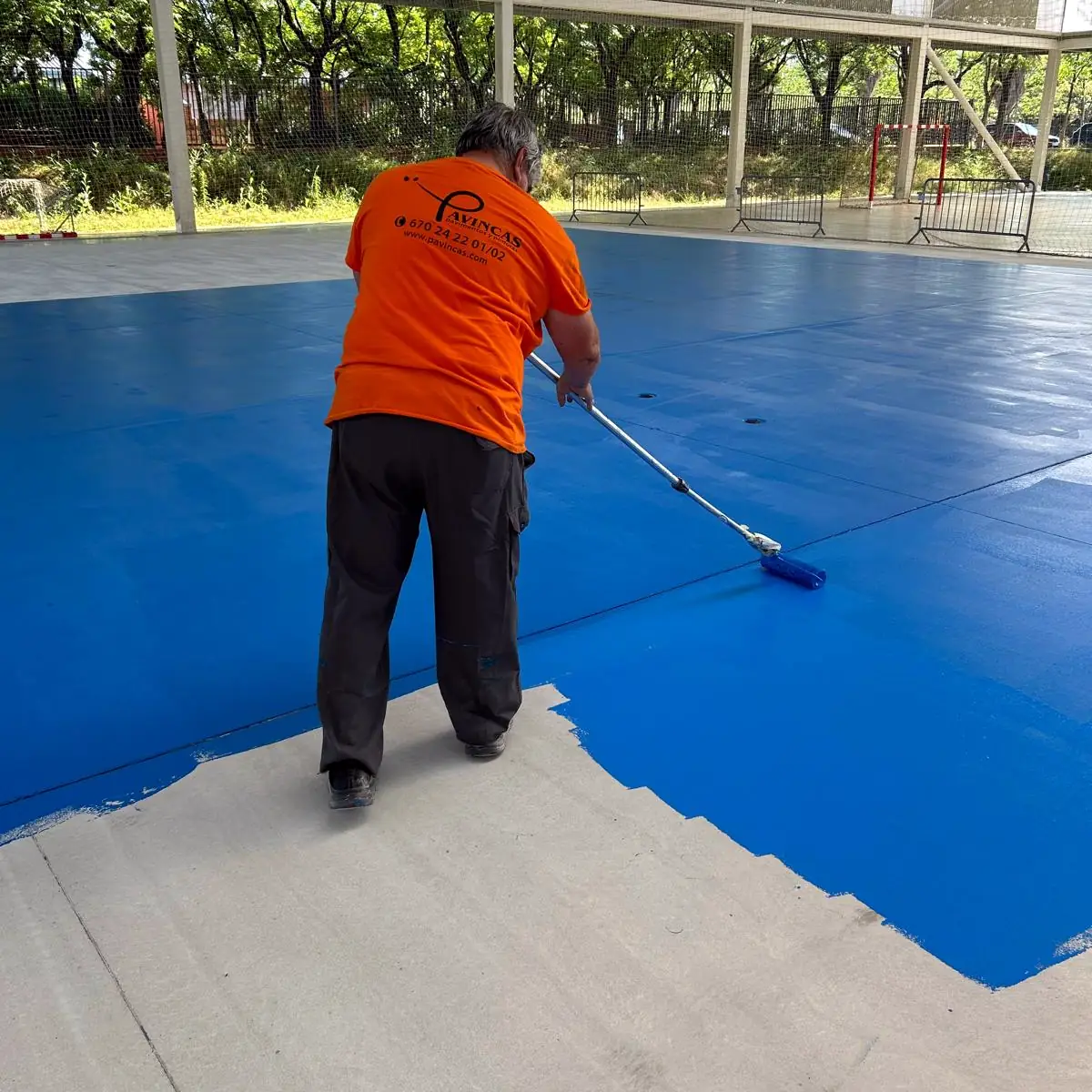 Pavincas applicator rolling blue coat over the pale base, Granollers