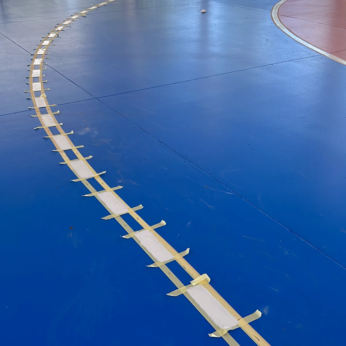 Masking tape set out for a curved line before painting