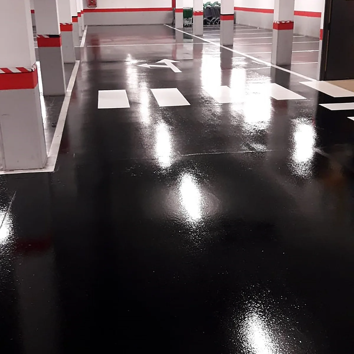 Pasillo largo en negro brillante con líneas blancas de plazas, Almería