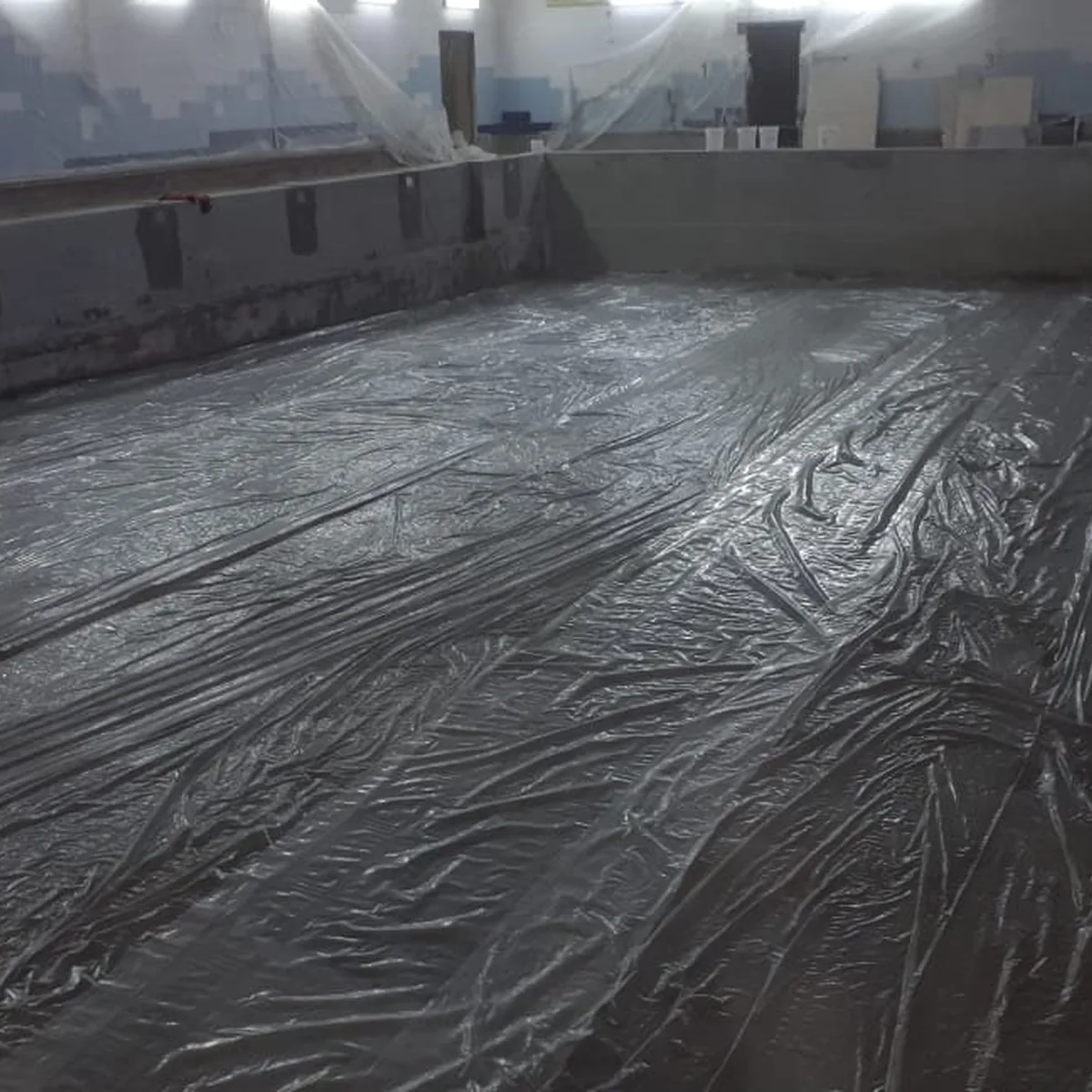 Dark membrane layer across the drained pool basin, Nizhny Novgorod