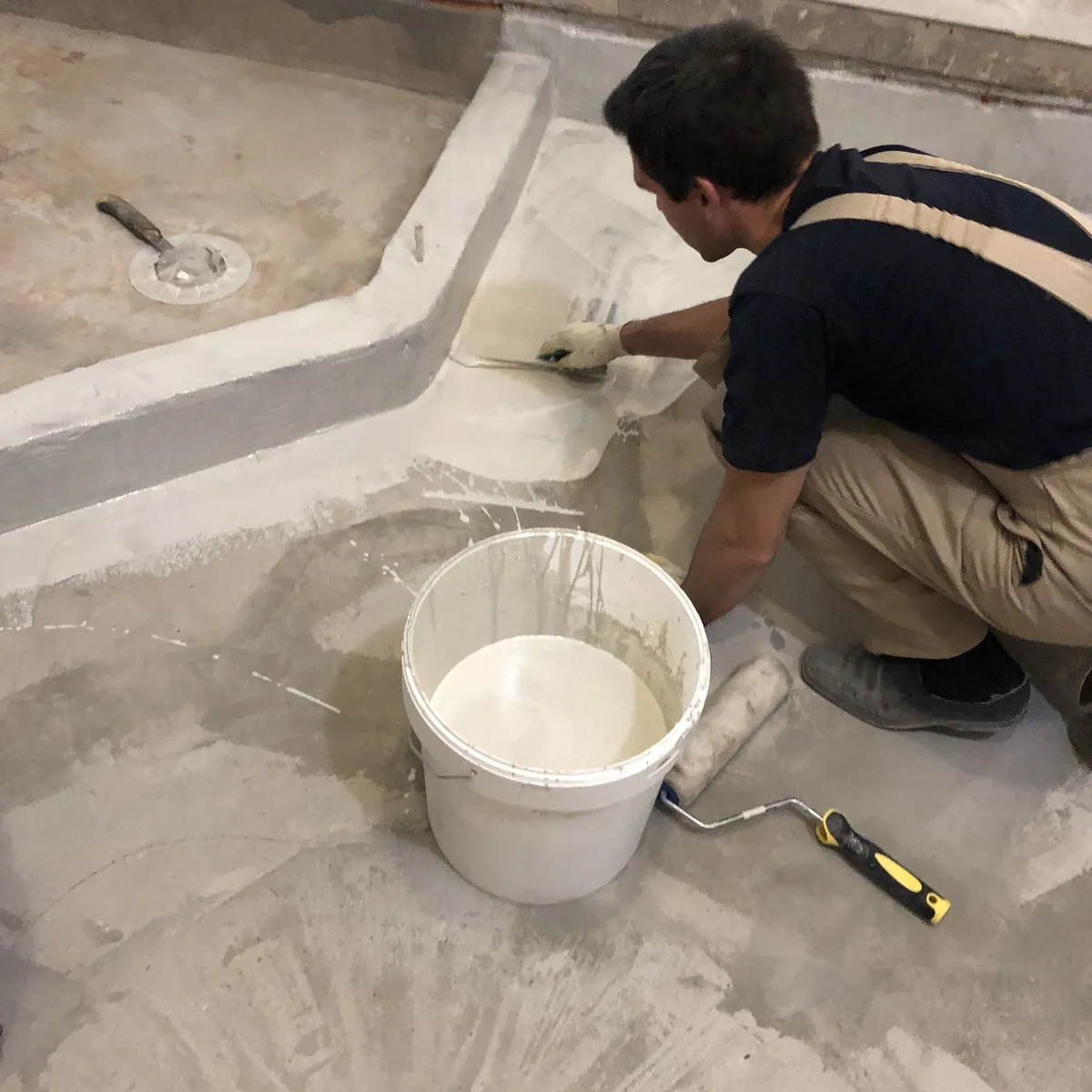 Applicator at a floor drain with a pail of material, Russia
