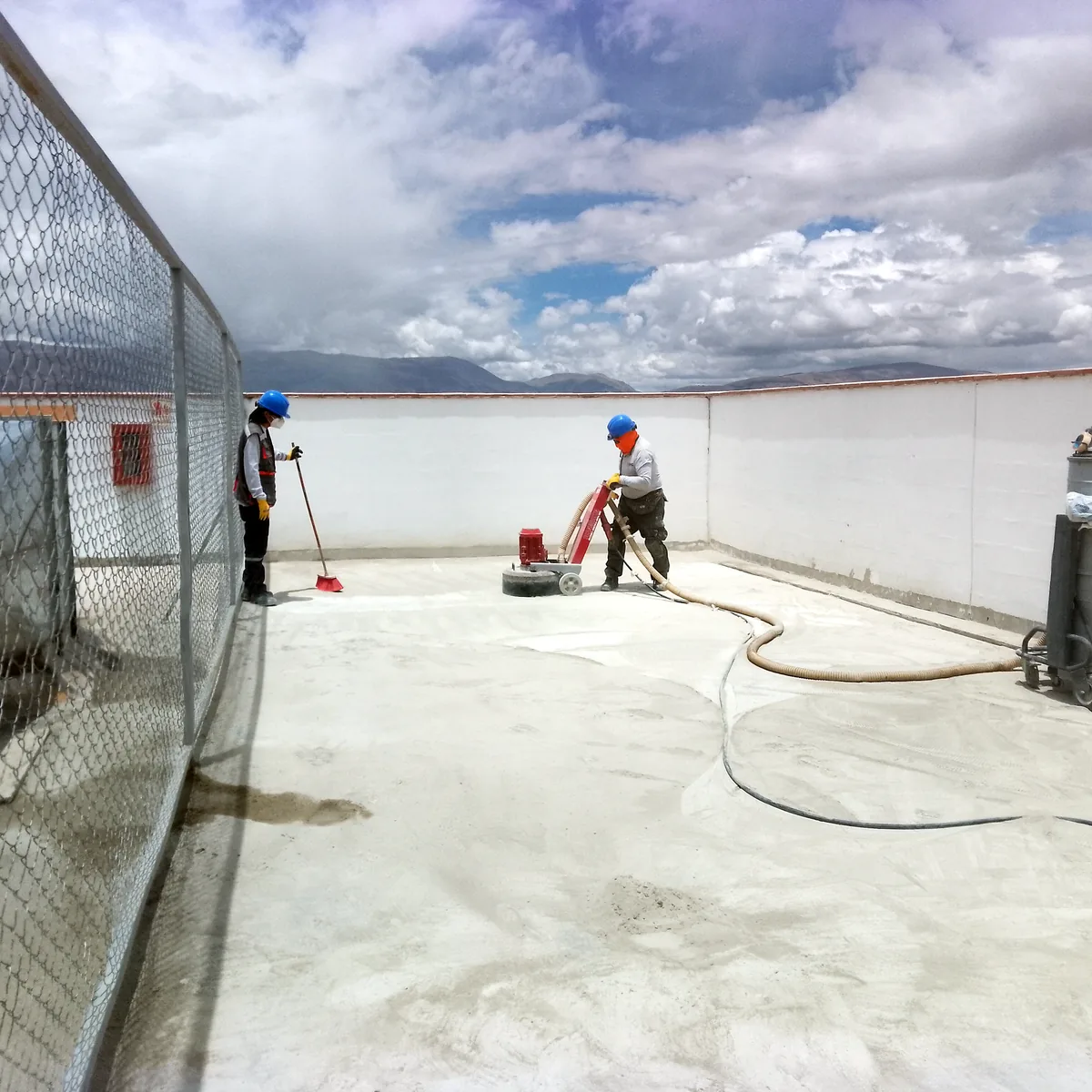 Operario con aspirador industrial preparando el soporte junto al cerramiento de cubierta, Huancayo