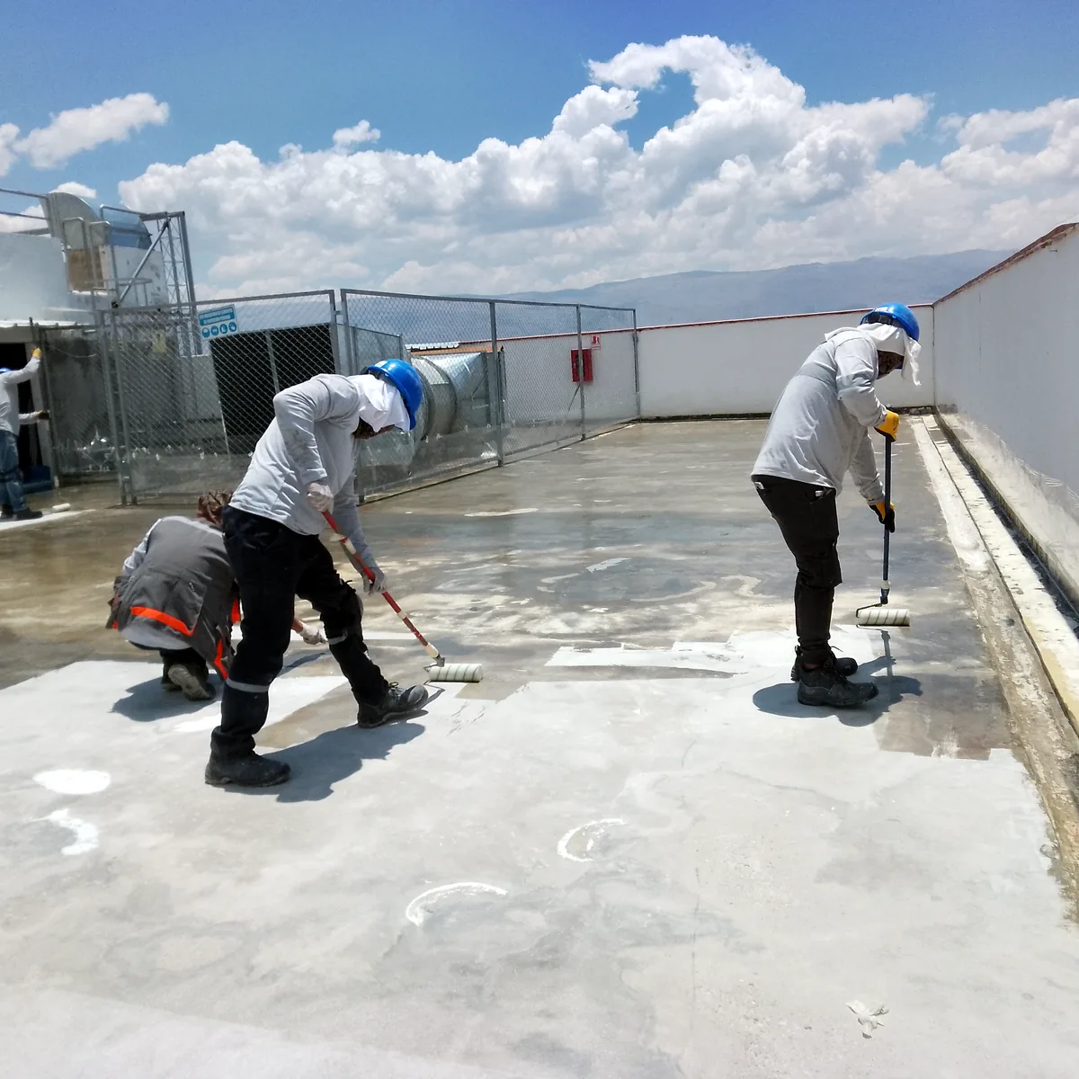 Dos operarios preparando el forjado junto a las casetas de instalaciones en cubierta