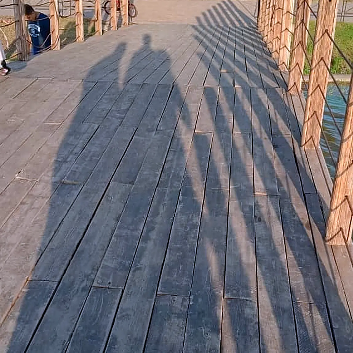 Shadows on the timber boardwalk next to the lake in 2026
