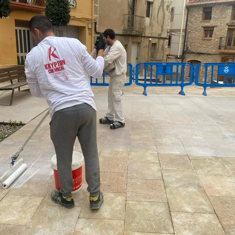 Dos operarios trabajando en el paño abierto de la plaza