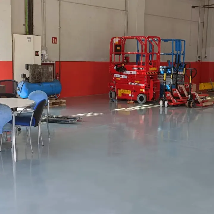 A scissor lift and trucks in the workshop bay