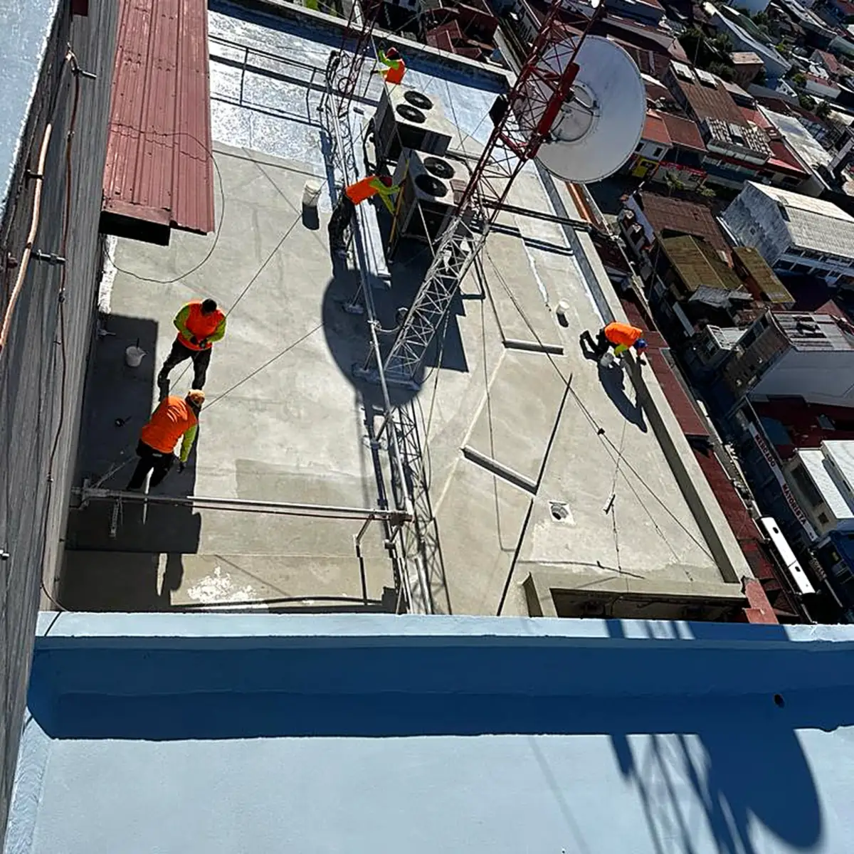 Applicators coating a lower roof level Applicators coating a lower roof level