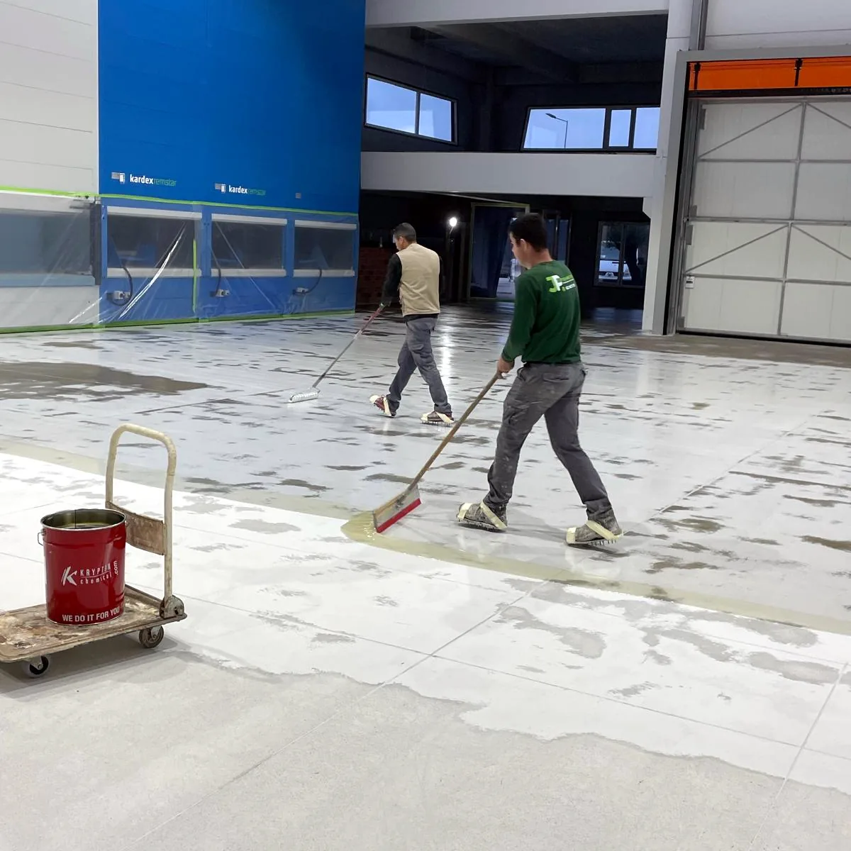 Warehouse polyaspartic flooring in Galicia going down with squeegees