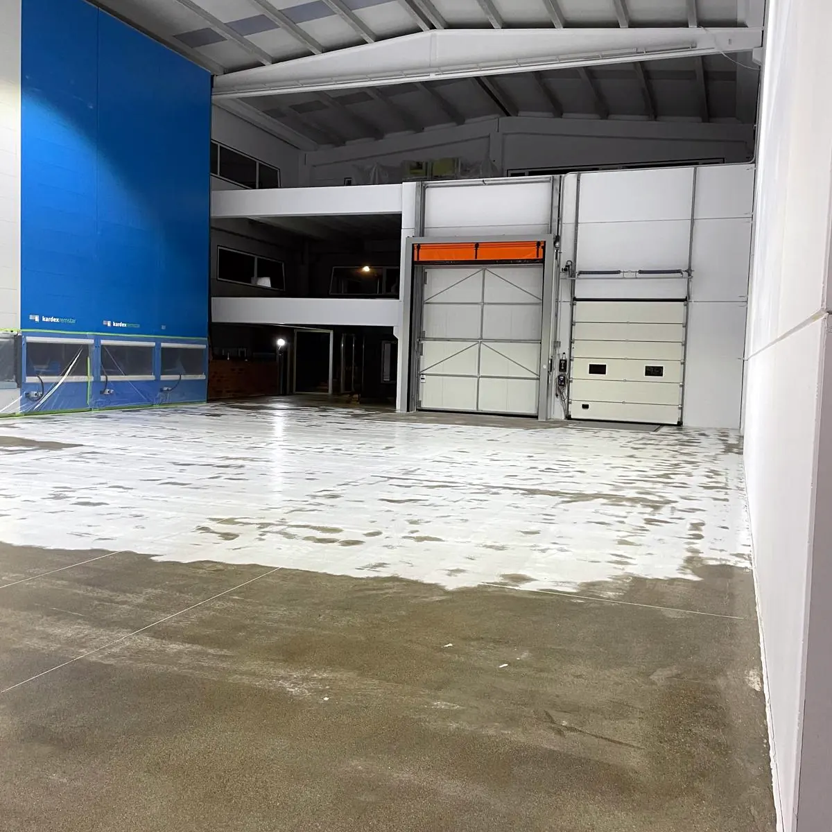 Warehouse polyaspartic flooring in Galicia, part done, by the blue wall