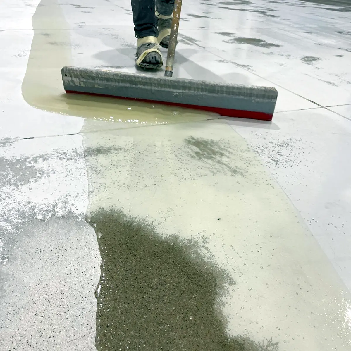 Squeegee pulling the light coat over the milled concrete, Galicia