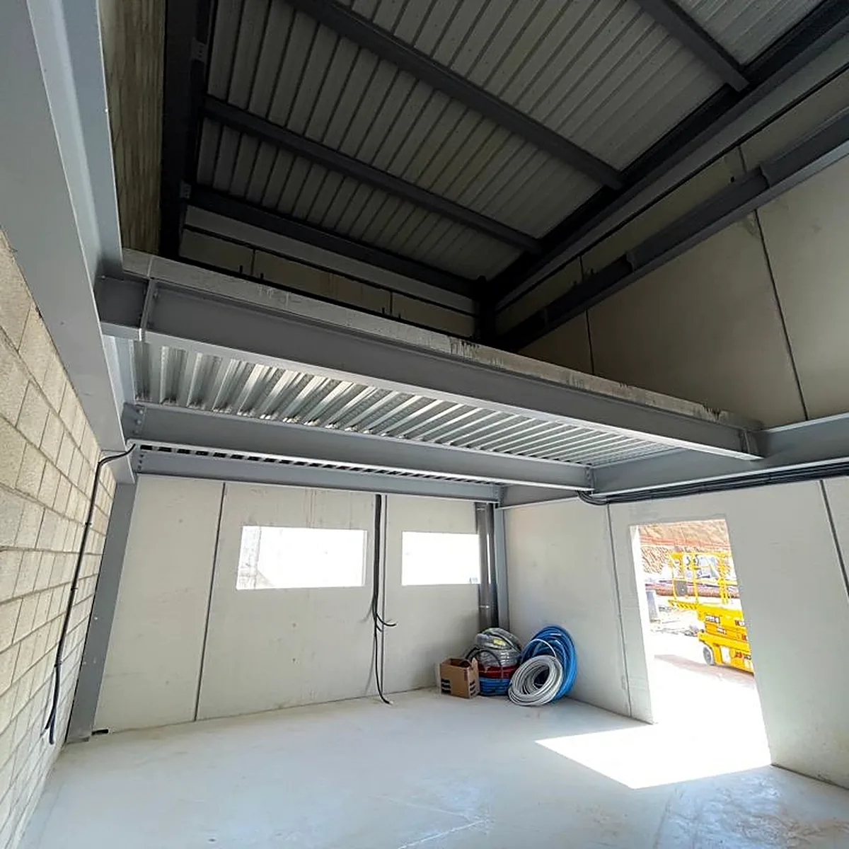Grey floor in a room below a steel deck, wastewater plant in Viladrau