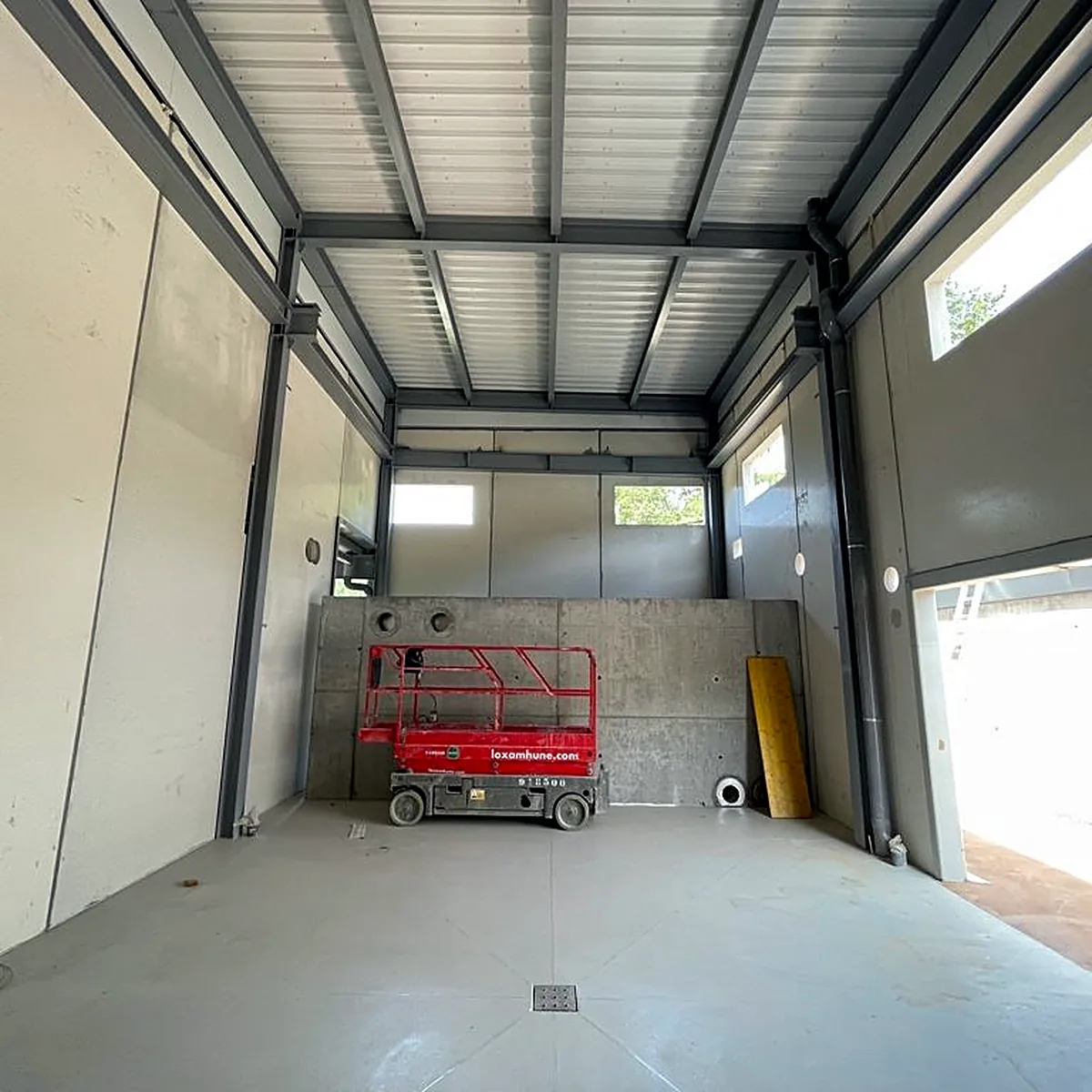 Tall hall with a floor drain and a lift at the back wall, Viladrau plant